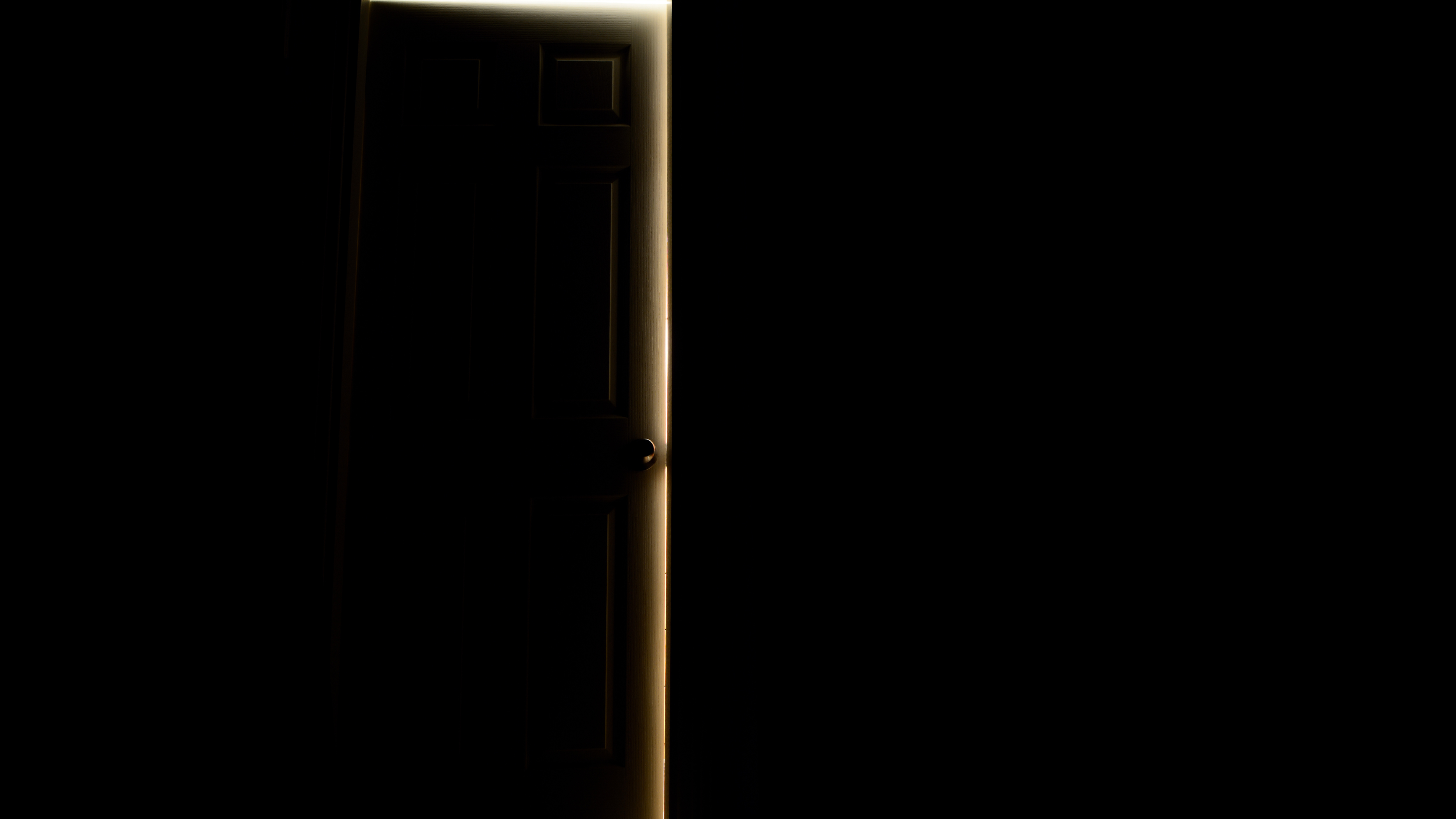 A door cracked open in darkness with warm light spilling through the edges, representing the 12 house parties of your birth chart astrology series by the earth siren