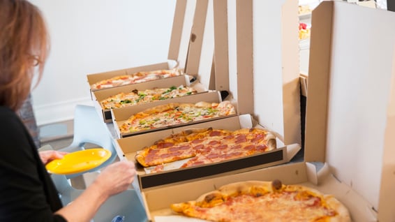 Office break room scene with several open pizza boxes, representing routine, workday choices, and 6th house astrology themes