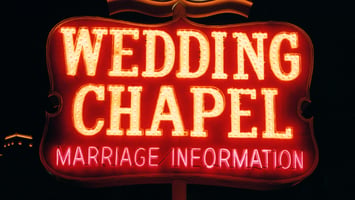 Intimate Las Vegas wedding chapel with warm lighting, fresh flowers, and elegantly dressed guests gathered for a spontaneous 7th house astrology wedding centered around partnership, commitment, and Venusian romance.