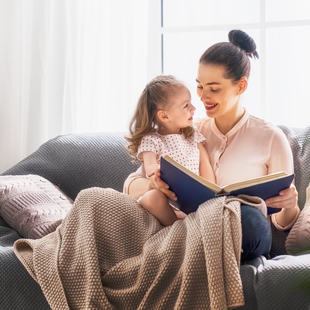 Parent reading with a young child in a calm home setting, representing parenting insight through astrology and birth chart understanding