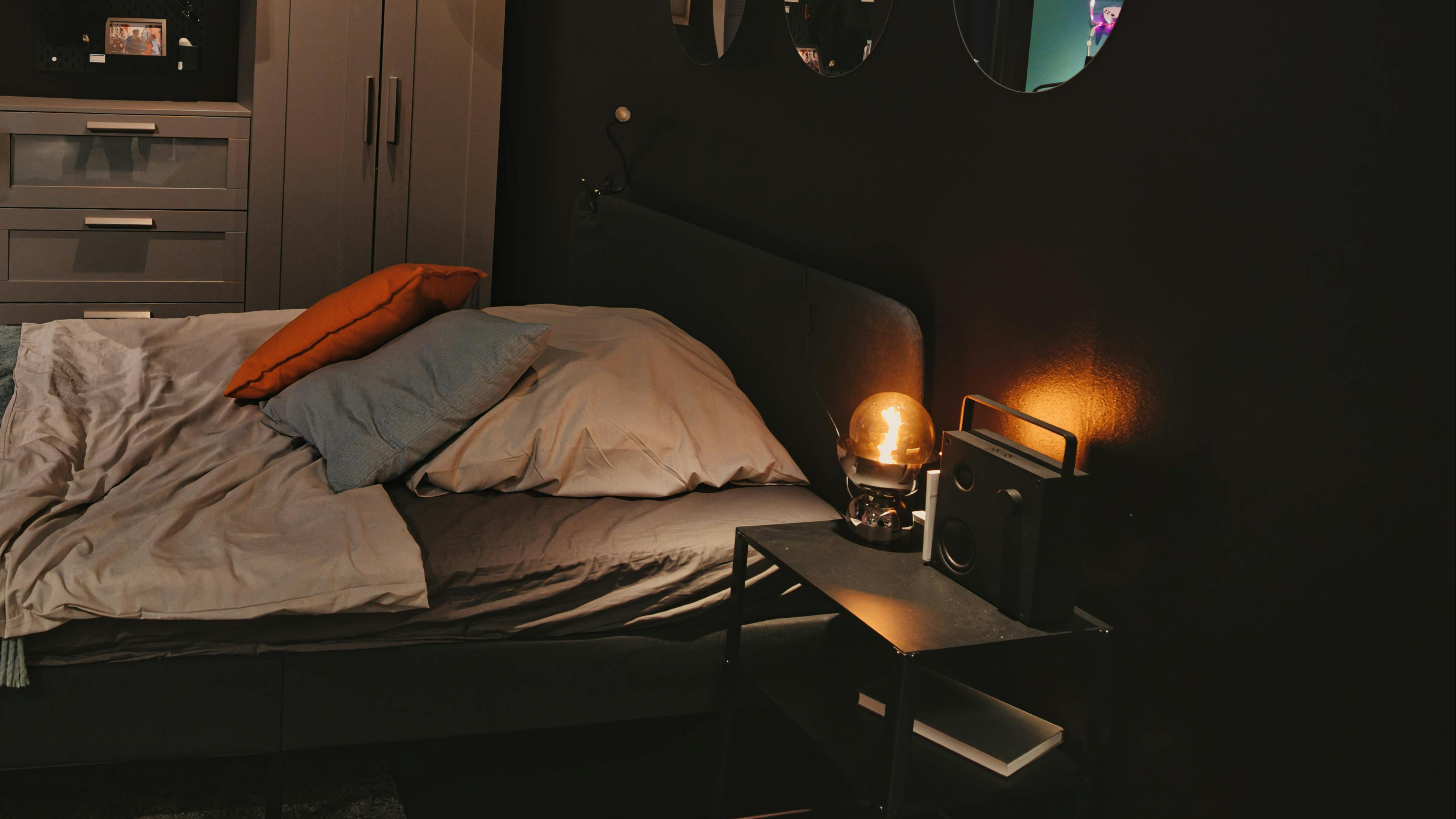 dimly lit bedroom at night with an unmade bed and a glowing desk in the background, representing moon sign sleep patterns and nighttime nervous system regulation bllog