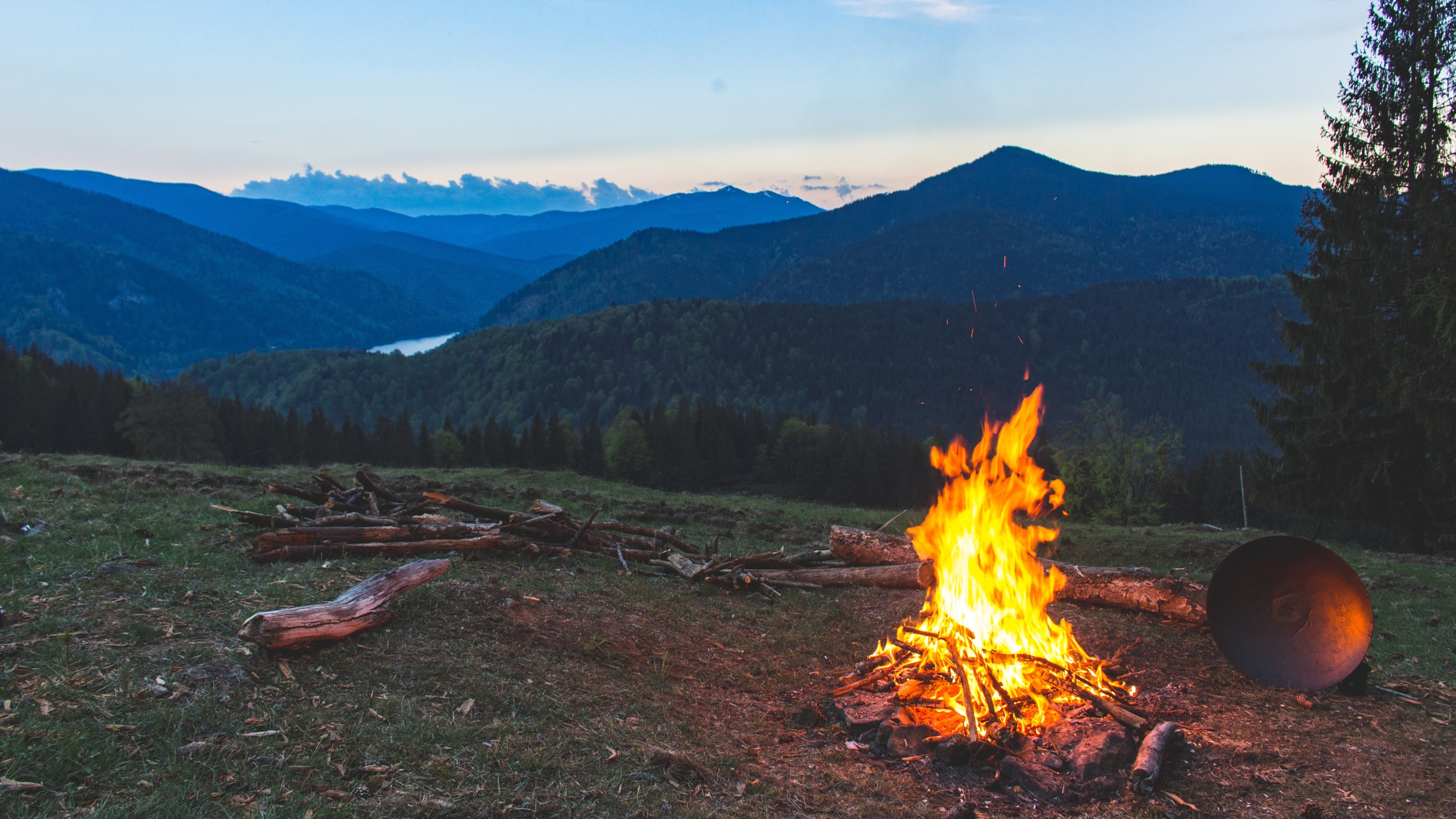 Campfire burning steadily on a quiet mountainside at dusk, reflecting Earth Siren astrology themes of fire sign energy and presence.
