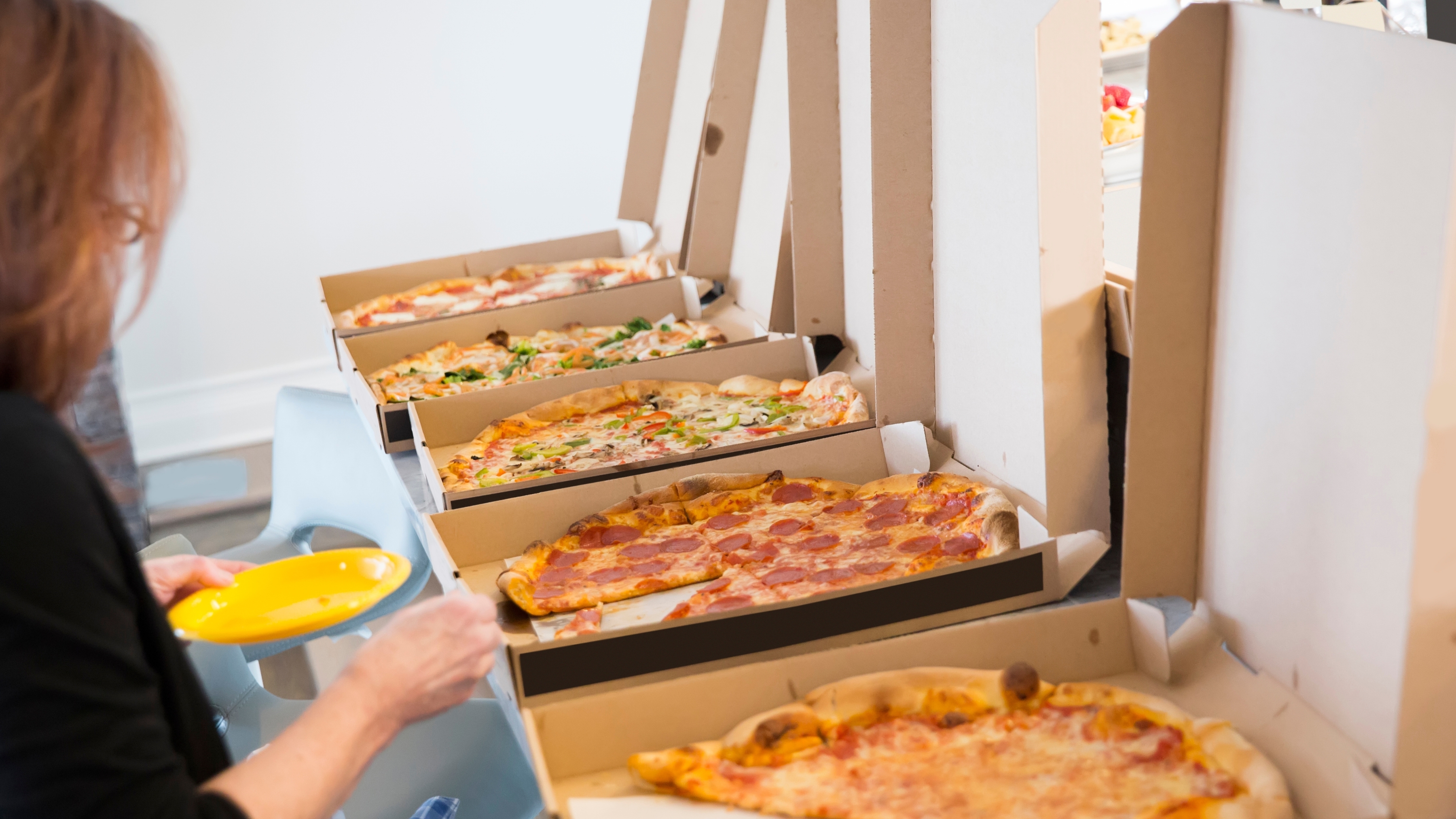 Office break room scene with several open pizza boxes, representing routine, workday choices, and 6th house astrology themes